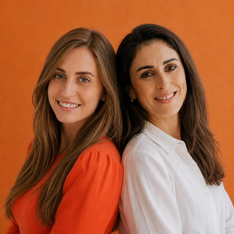 Laura, de blusa laranja, e Sílvia, de camisa branca, sorrindo lado a lado